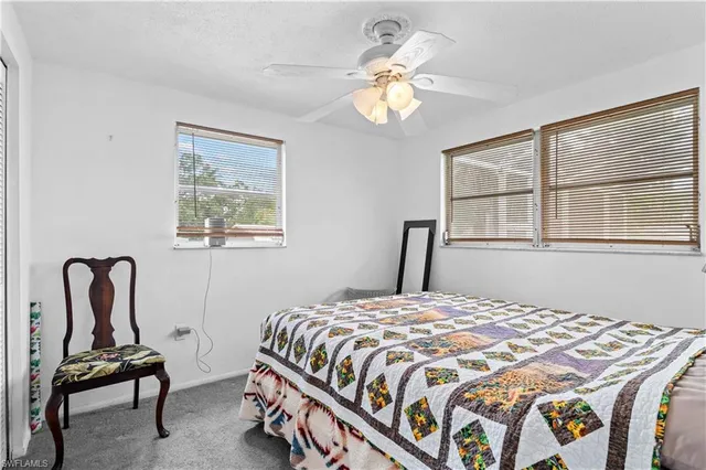 a bedroom with a bed chair and window