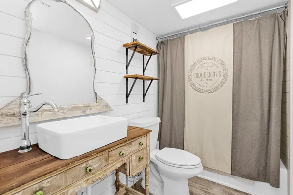 a bathroom with a sink a toilet and a mirror