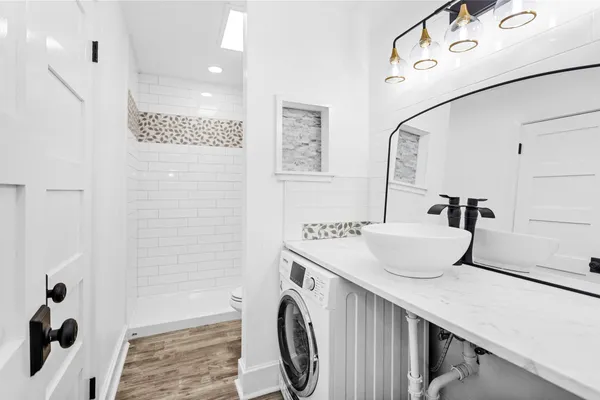 a bathroom with a sink a toilet and shower