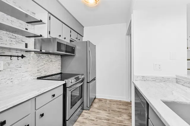 a kitchen with stainless steel appliances granite countertop a sink stove and refrigerator