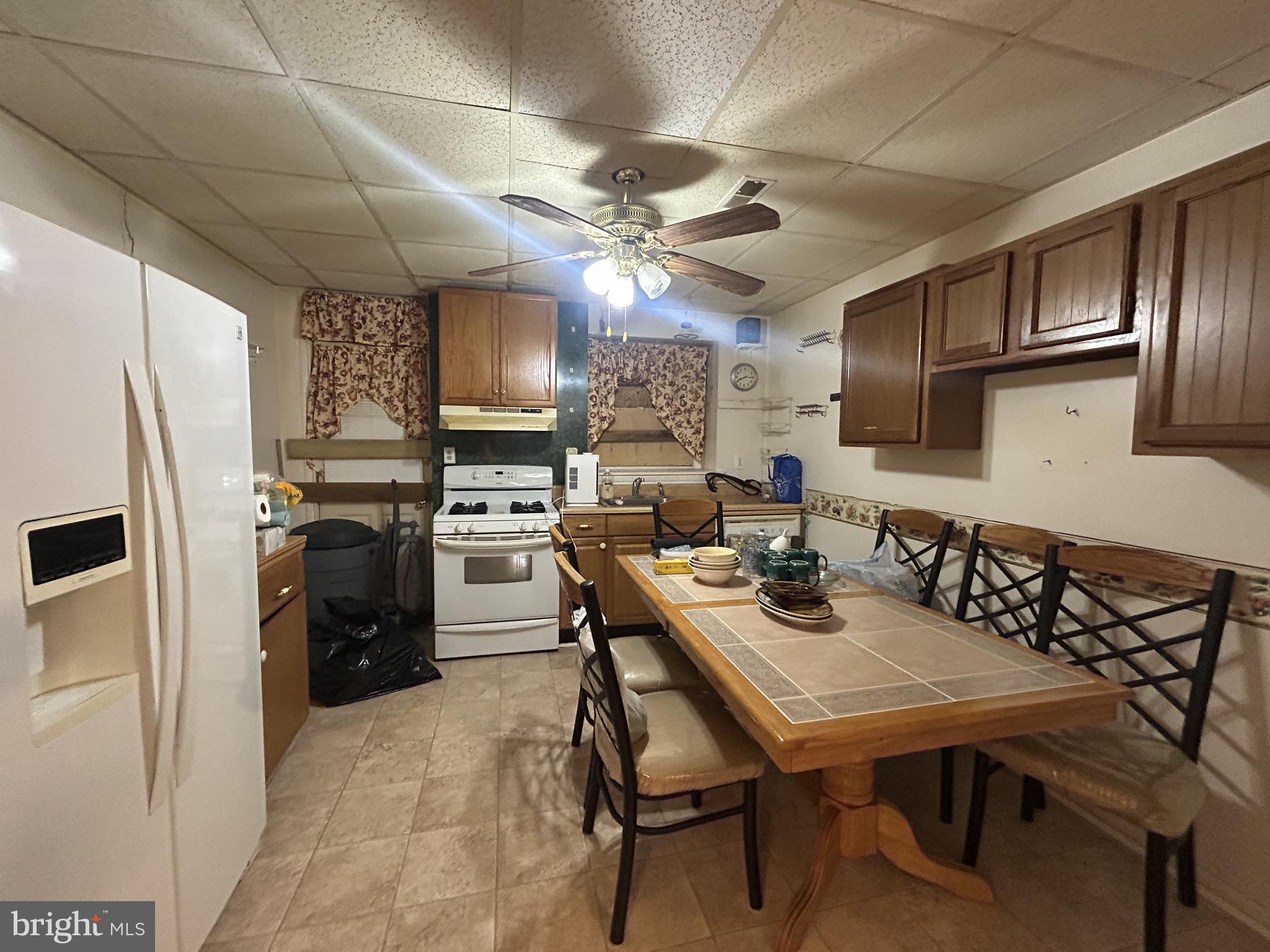 307 South Mount Street Baltimore, MD 21223 - Photo 7 of 17 a kitchen with refrigerator cabinets dining table and chairs