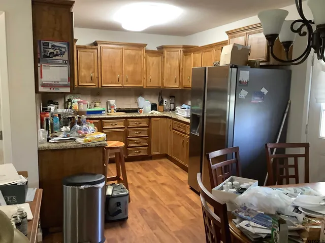 a kitchen with stainless steel appliances granite countertop a stove refrigerator and cabinets