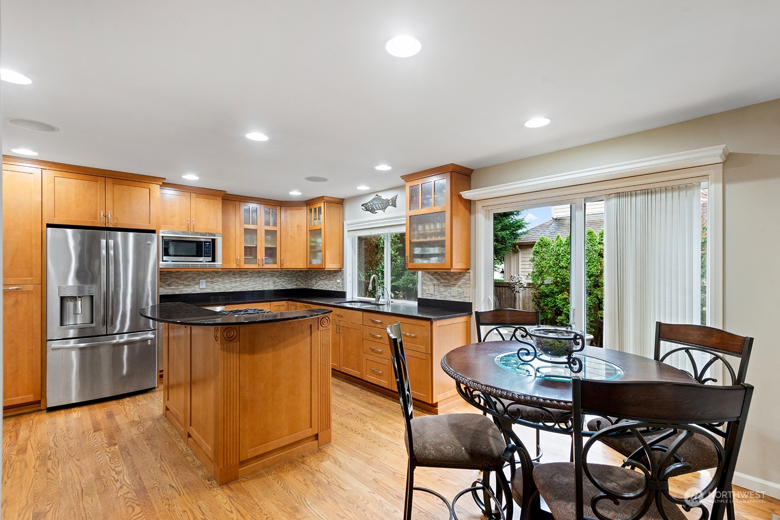 3930 208th Place Southeast Bothell, WA 98021 - Photo 10 of 36 a kitchen with stainless steel appliances granite countertop a stove a refrigerator a dining table and chairs