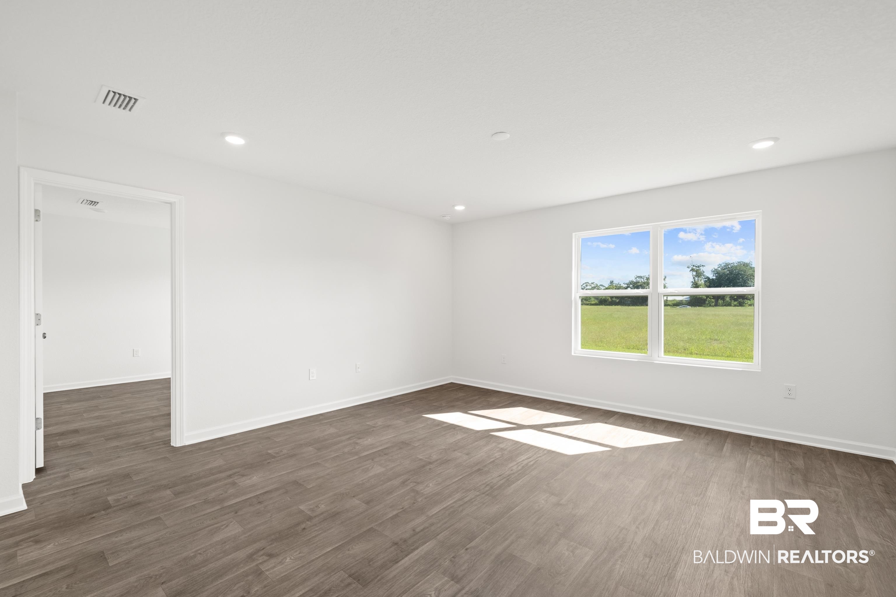 14615 Dayton Circle Foley, AL 36535 - Photo 17 of 27 Spacious room featuring wood-finish flooring, white baseboards, and crisp white walls