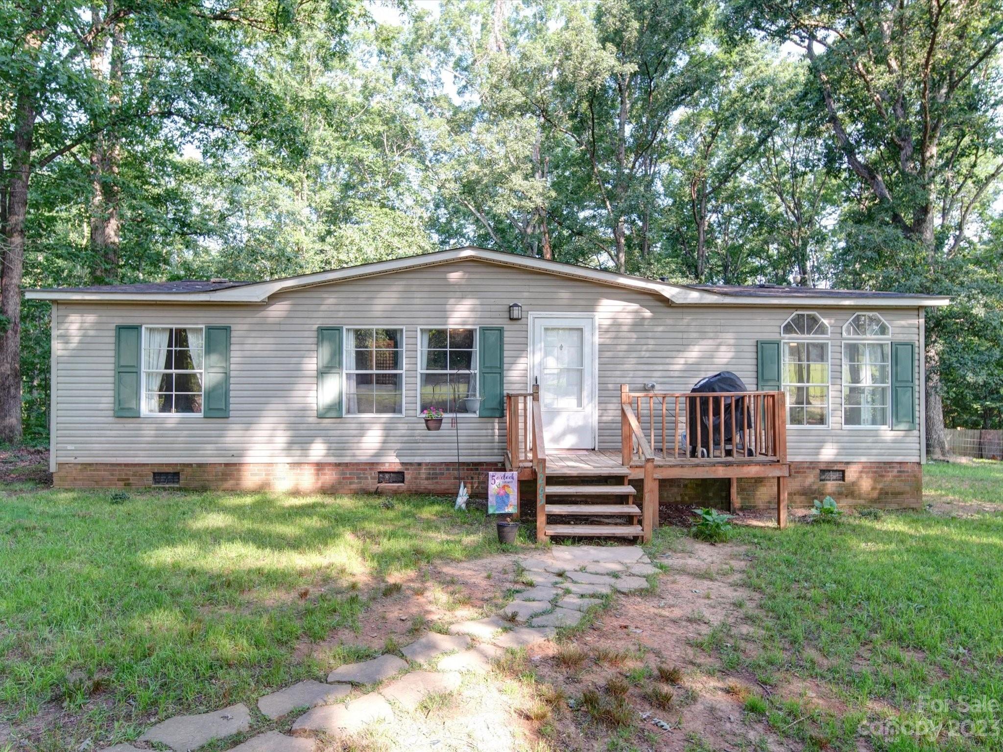 1265 Polk Ford Road Stanfield, NC 28163 - Photo 1 of 40 a front view of a house with a yard table and chairs