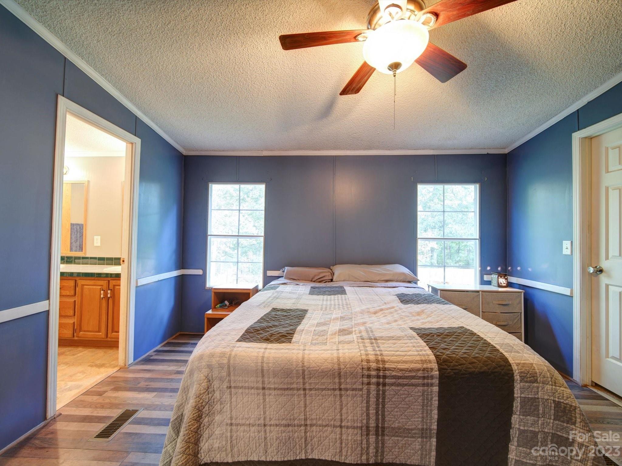 1265 Polk Ford Road Stanfield, NC 28163 - Photo 17 of 40 a bedroom with a large bed and a chandelier