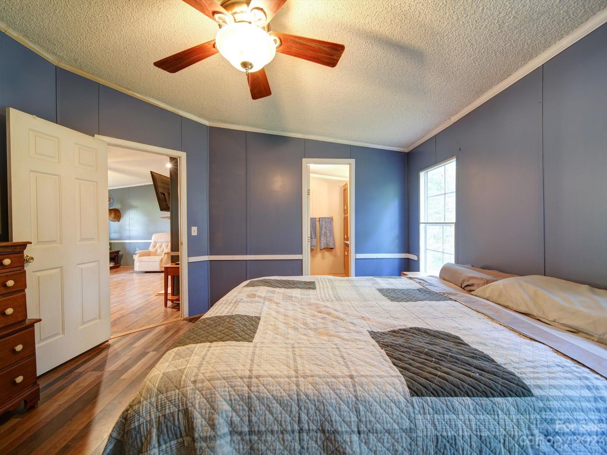 1265 Polk Ford Road Stanfield, NC 28163 - Photo 19 of 40 a bedroom with a large bed and a chandelier