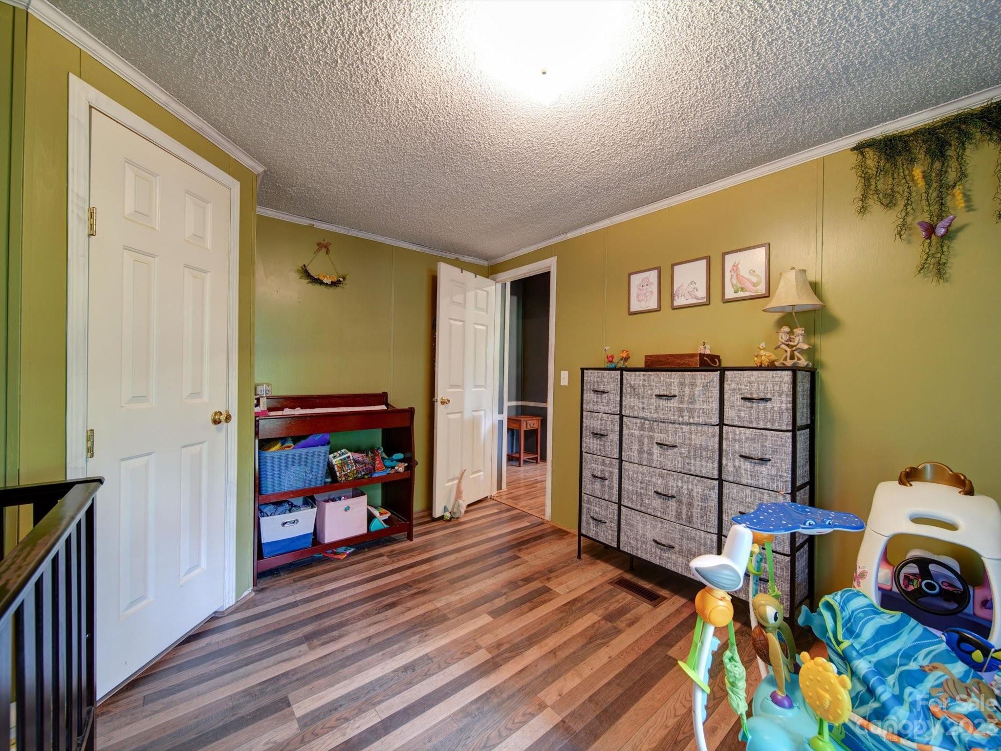 1265 Polk Ford Road Stanfield, NC 28163 - Photo 32 of 40 a view of a bedroom with baby crib and furniture