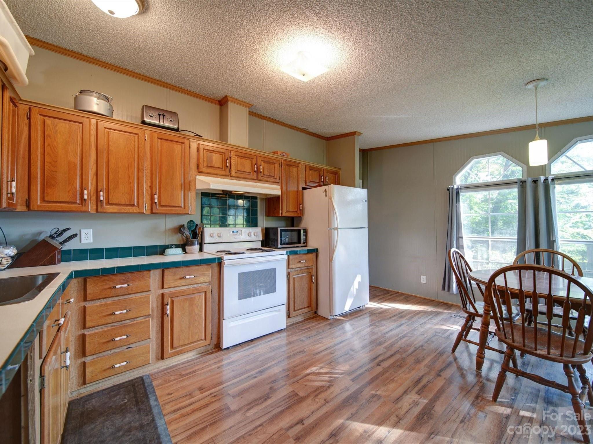 1265 Polk Ford Road Stanfield, NC 28163 - Photo 9 of 40 a kitchen with stainless steel appliances wooden floors and wooden cabinets