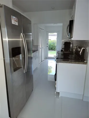 a view of a kitchen with a refrigerator a stove top oven and a refrigerator