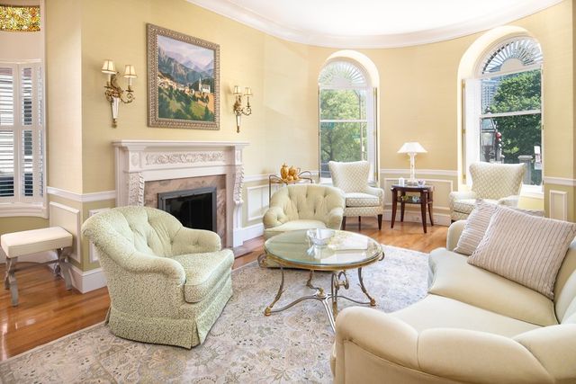 a living room with furniture a fireplace and a large window