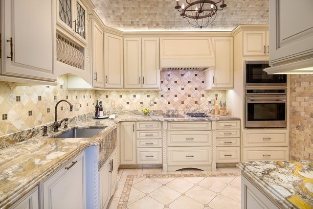 a kitchen with granite countertop white cabinets and stainless steel appliances