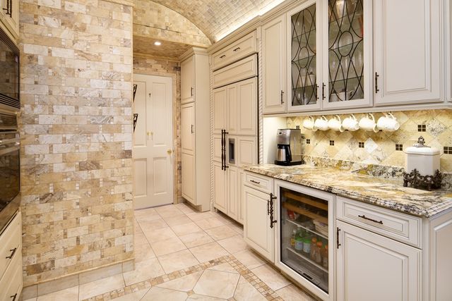 a kitchen with granite countertop a stove a sink and a refrigerator