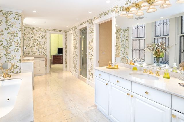 a spacious bathroom with a tub sink and mirror