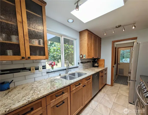 a kitchen with stainless steel appliances granite countertop a stove a refrigerator and a microwave