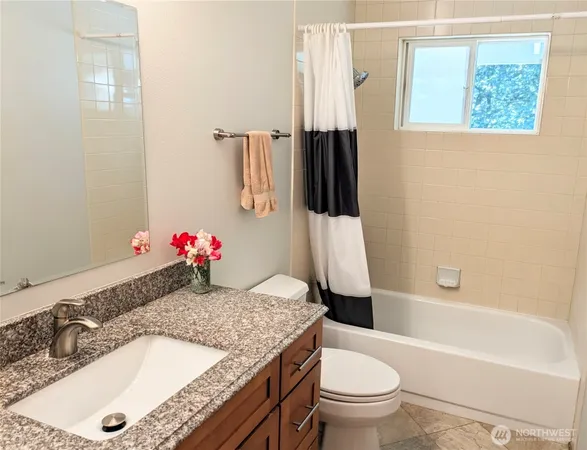 a bathroom with a granite countertop sink toilet and shower