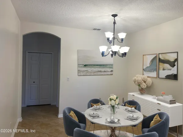 a view of a dining room with furniture and chandelier