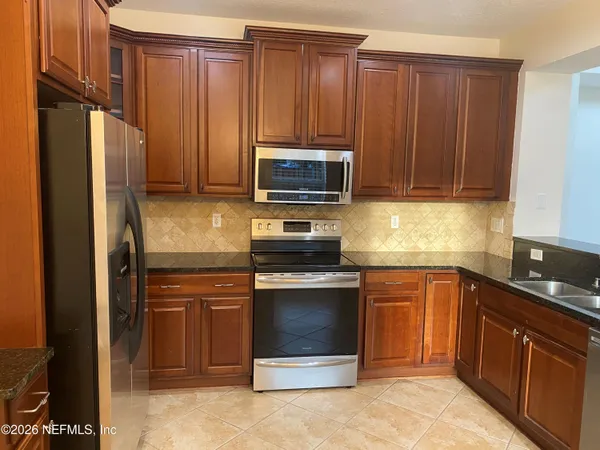 a kitchen with granite countertop wooden cabinets and stainless steel appliances