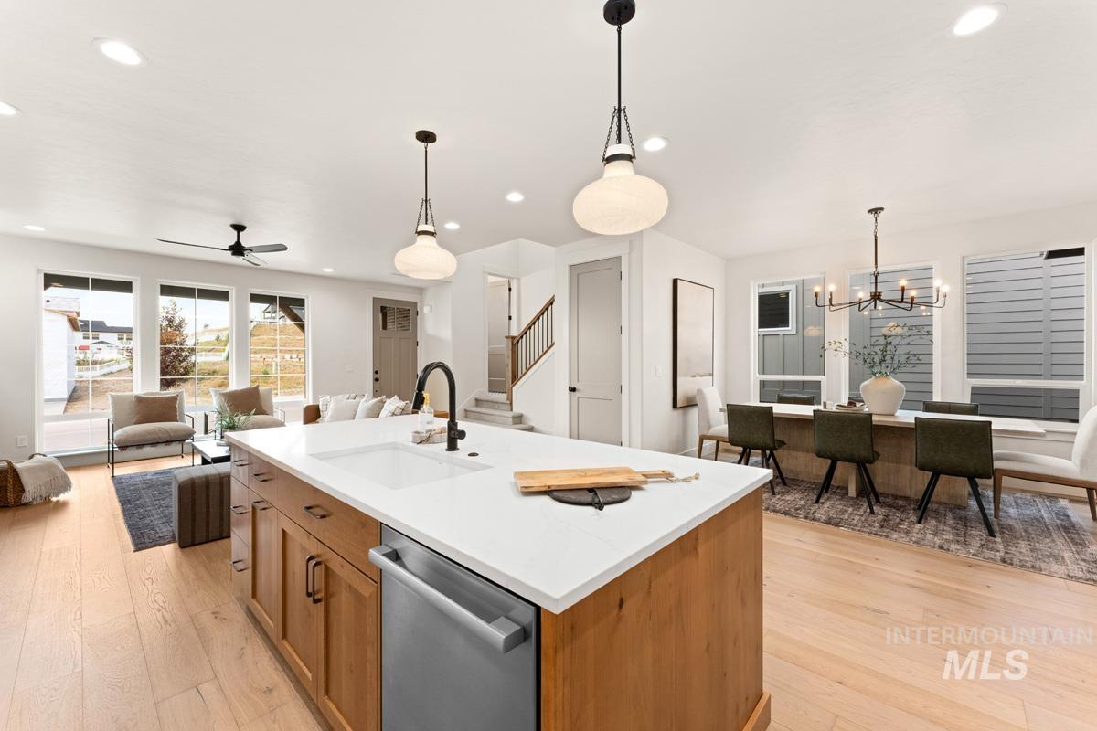 13338 North Spring Creek Way Boise, ID 83714 - Photo 6 of 46 Kitchen island with white countertop, integrated sink, and stainless steel dishwasher