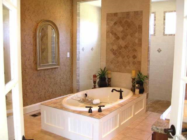 3320 La Costa Way Raleigh, NC 27610 - Photo 5 of 10 Designed by the previous owner this bathroom is unique! Tons of tile & granite! The stand alone jetted garden tub is the focal point while behind you have an open style shower with two entrances & transom style windows natural light! Other