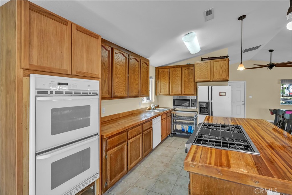16410 Tish-A-Tang Road Lower Lake, CA 95457 - Photo 32 of 48 a kitchen with wooden cabinets and a stove top oven