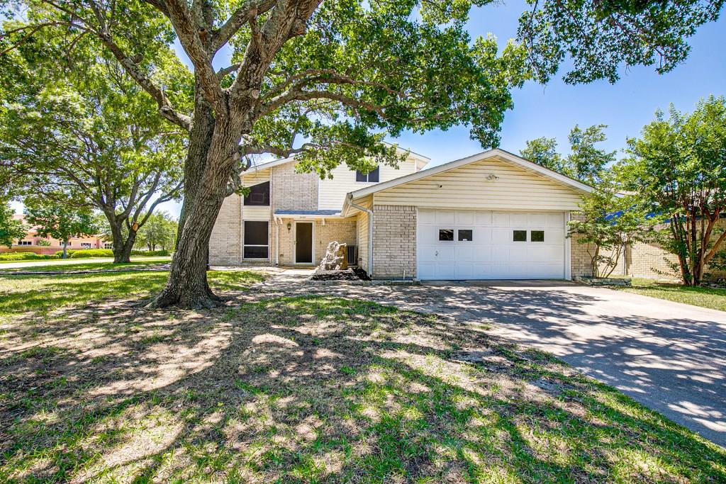 a view of a house with a tree in front of it