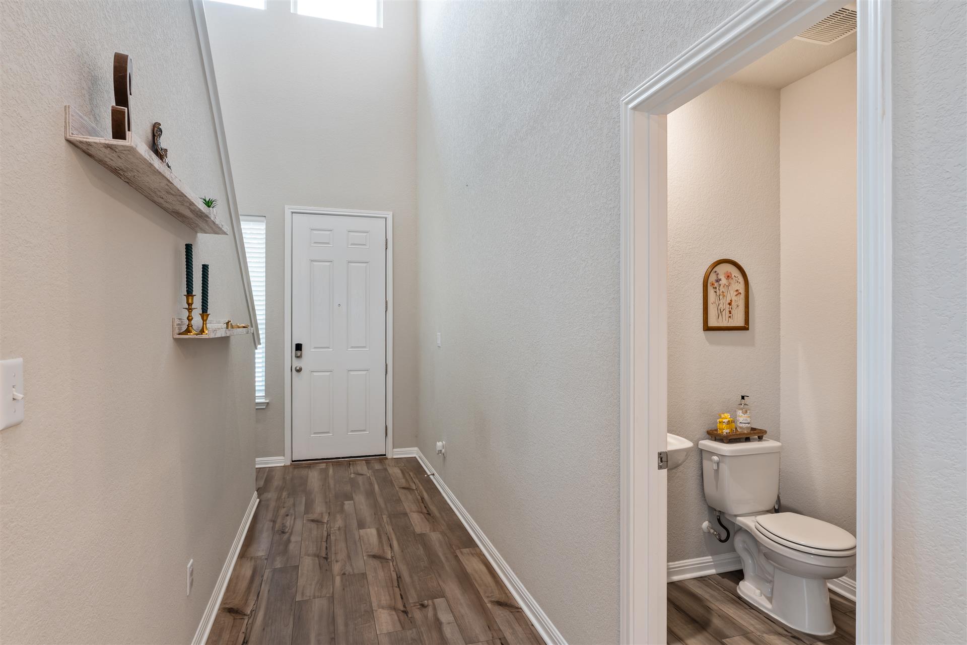 331 Mountain Valley Street Georgetown, TX 78628 - Photo 40 of 40 The home flows beautifully as you enter into the open concept floorplan with the staircase on the right and powder bath on the left, featuring wood-style flooring