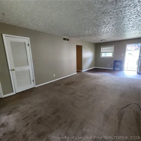 a view of a big room with windows and refrigerator