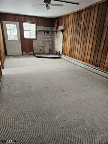 a view of an empty room with a fireplace and windows