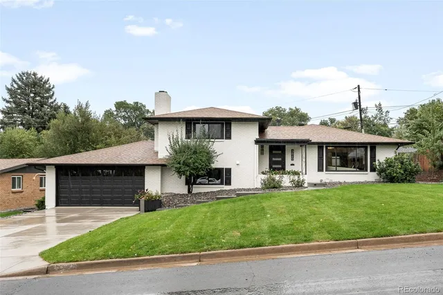 a front view of a house with a garden and plants