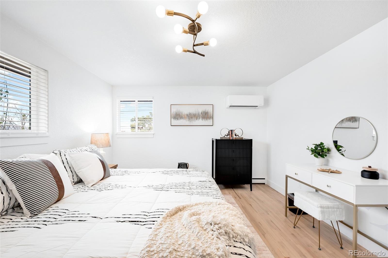 3860 Dudley Street Wheat Ridge, CO 80033 - Photo 15 of 35 a bedroom with a large bed and a chandelier
