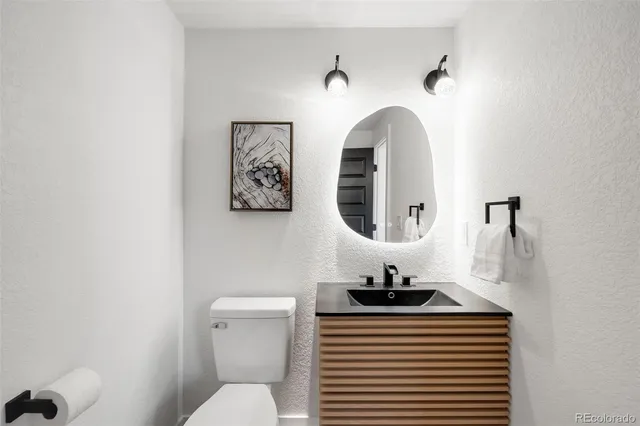 a bathroom with a sink mirror and toilet