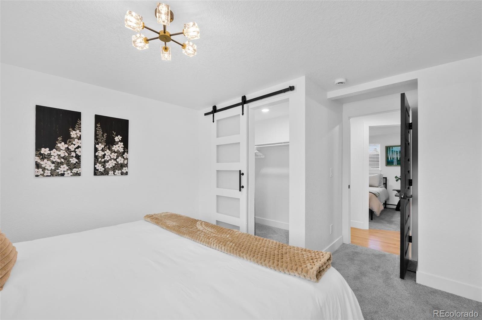 3860 Dudley Street Wheat Ridge, CO 80033 - Photo 16 of 35 a bedroom with a bed and a chandelier