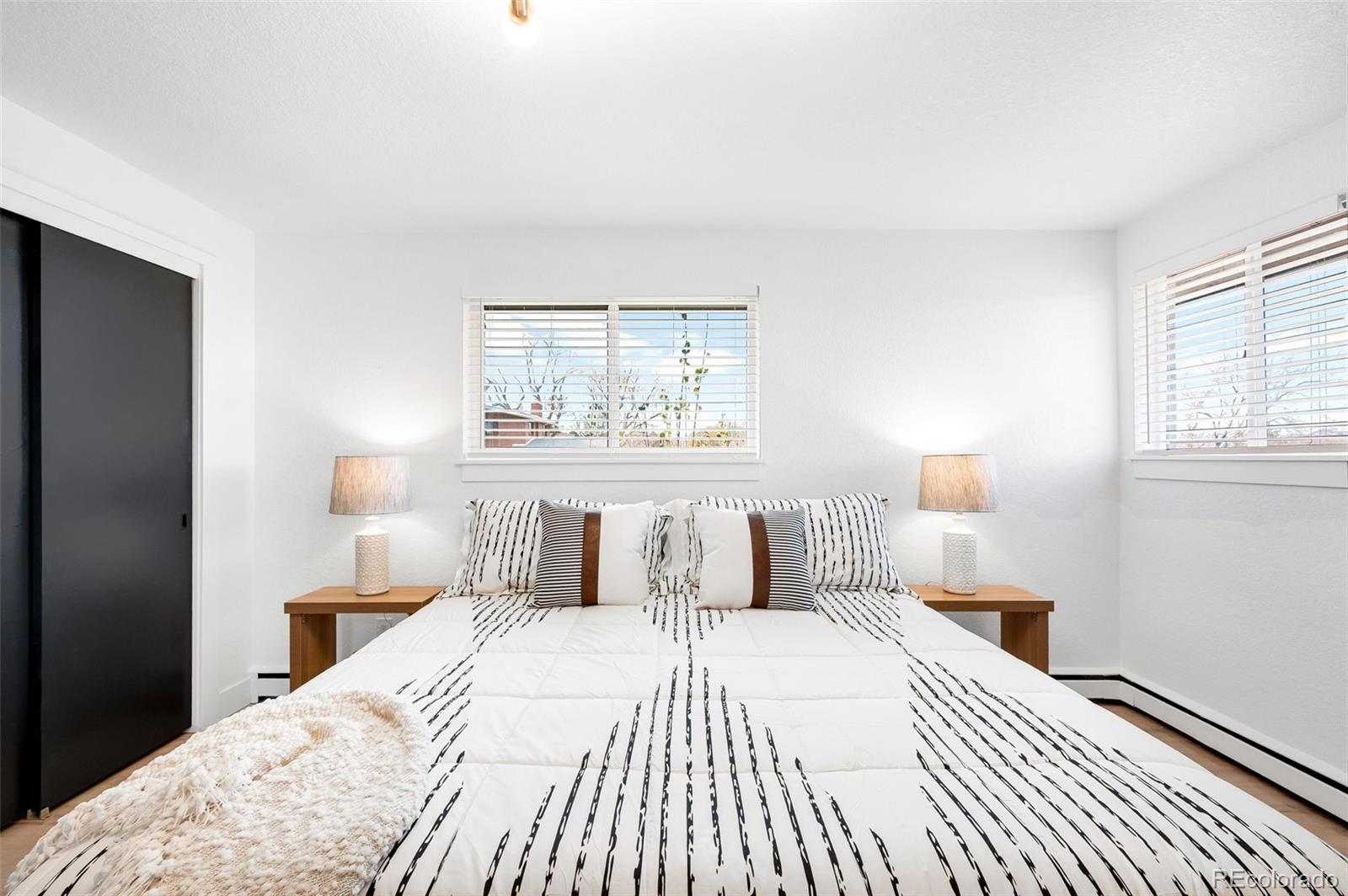 3860 Dudley Street Wheat Ridge, CO 80033 - Photo 19 of 35 a bedroom with a bed and a night stand