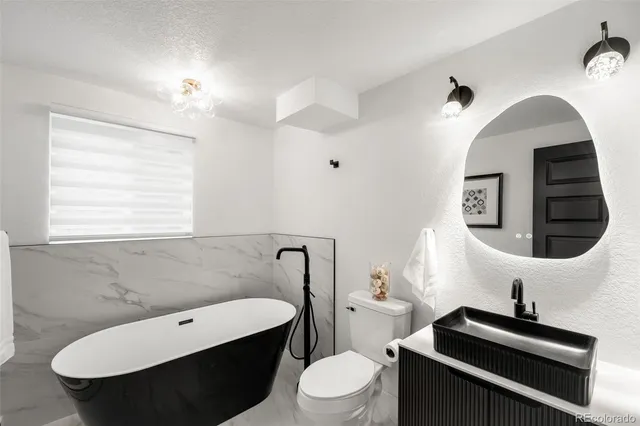 a bathroom with a sink a toilet and a mirror