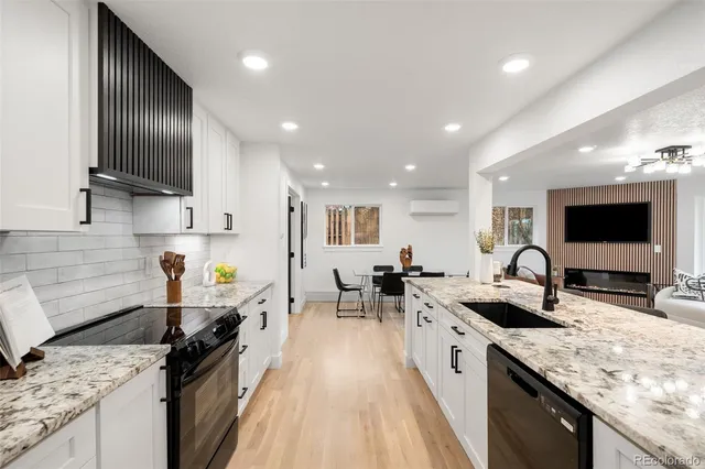 a large kitchen with stainless steel appliances granite countertop a sink stove and refrigerator