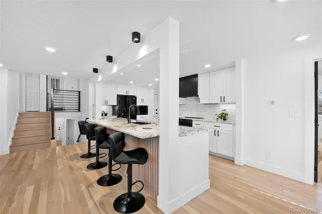 a kitchen with a sink stove top oven and refrigerator