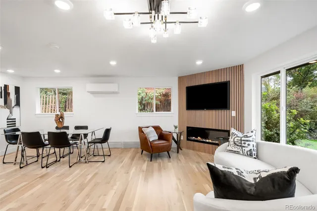 a living room with furniture a flat screen tv and a large window