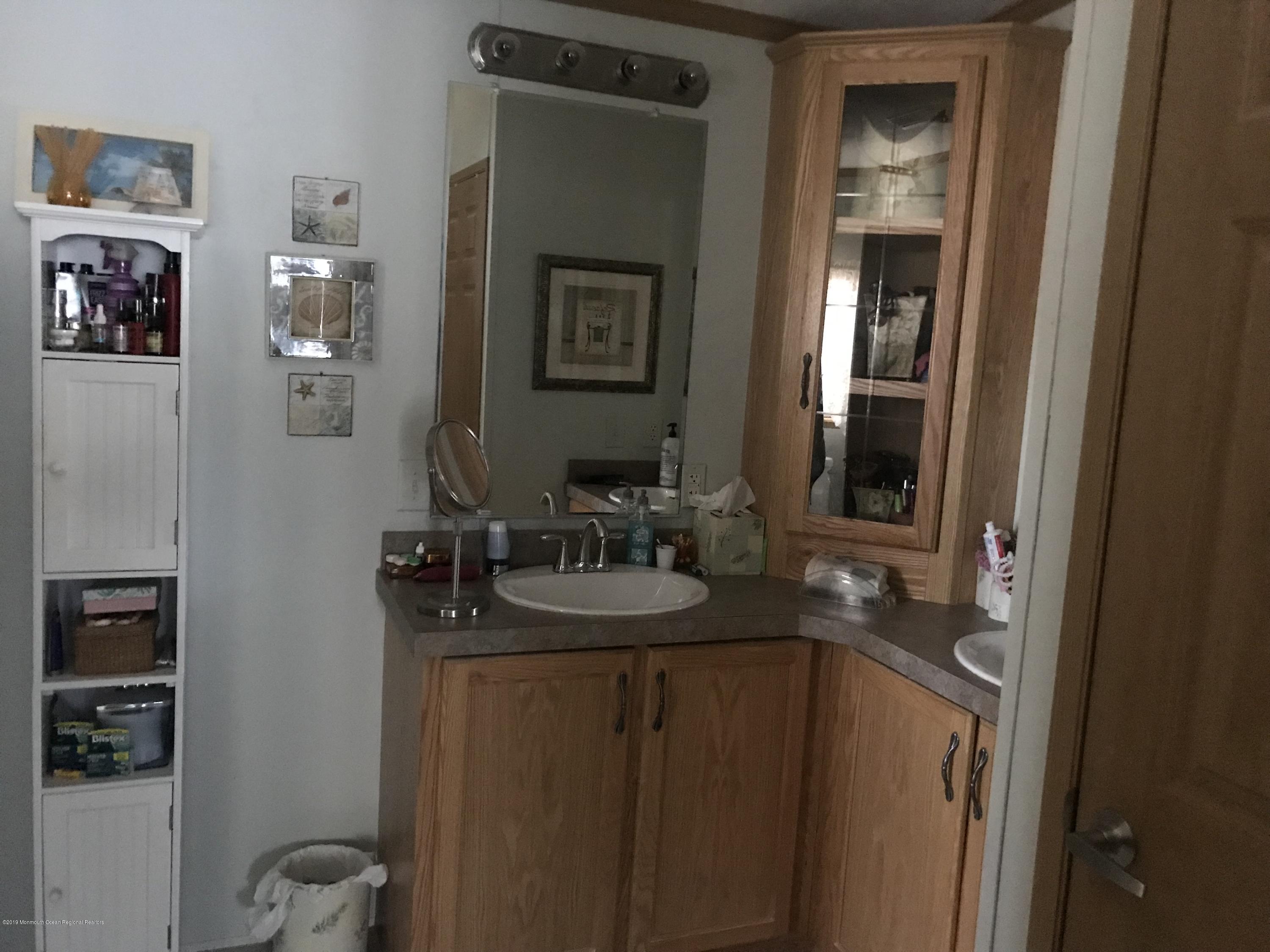 204 Roberts Road Toms River, NJ 08755 - Photo 17 of 19 a bathroom with a sink and a mirror