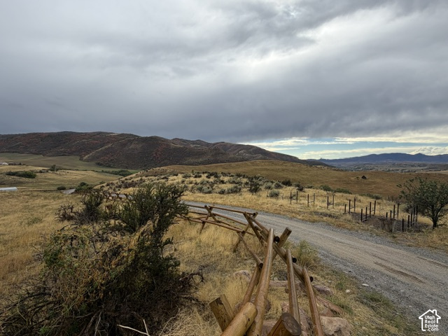 4458 East Glencoe Road Preston, ID 83263 - Photo 6 of 52 Gravel road with a rustic split-rail fence, surrounded by expansive natural terrain and distant hills
