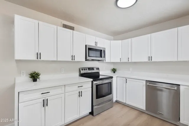 a kitchen with white cabinets and white appliances