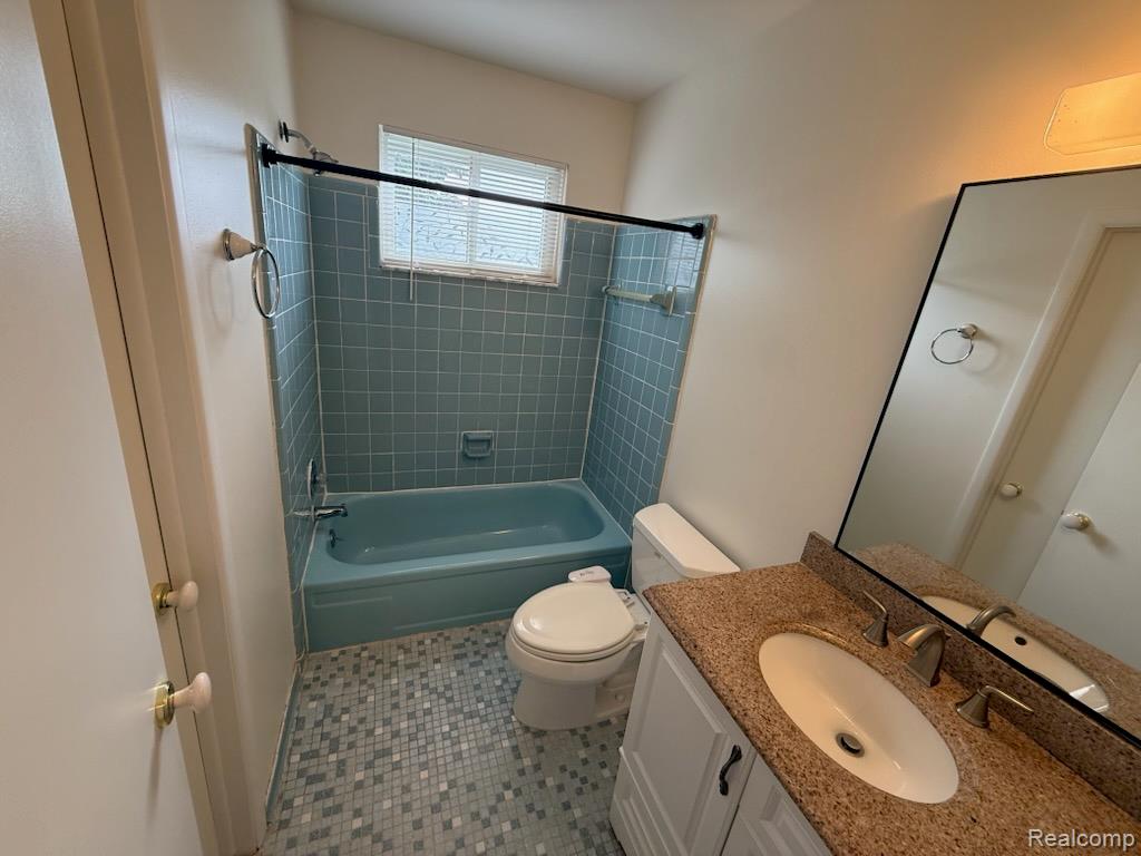 28144 Yorktown Road Farmington, MI 48331 - Photo 18 of 25 Bathroom featuring a light blue tiled shower surround, a matching bathtub, and a mosaic tile floor