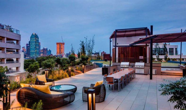 4-75 48th Avenue, Unit 1502 Queens, NY 11109 - Photo 11 of 12 a outdoor space with patio fireplace and outdoor seating