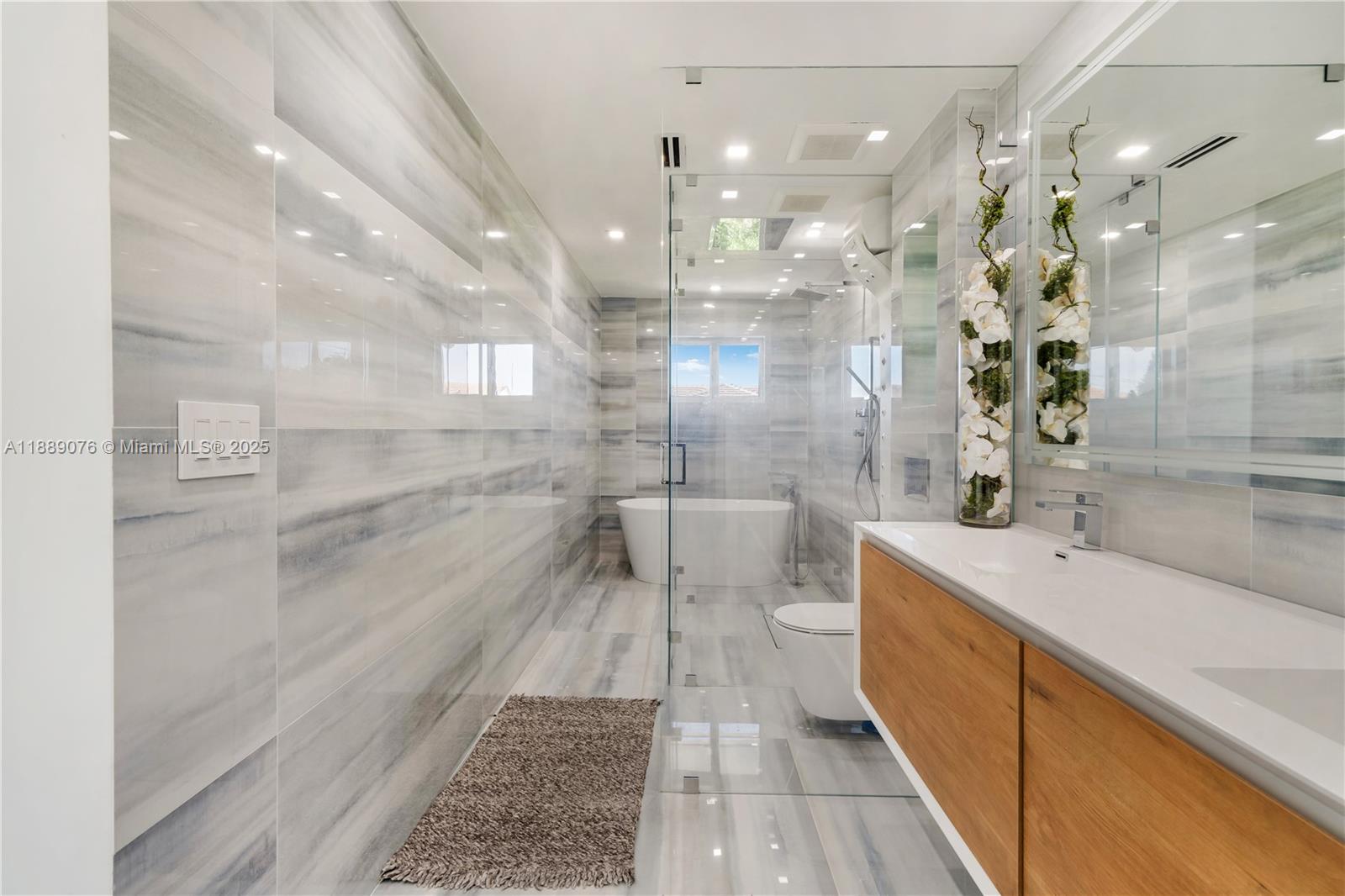 6763 Southwest 106th Place Miami, FL 33173 - Photo 19 of 38 a bathroom with a sink a shower and a mirror