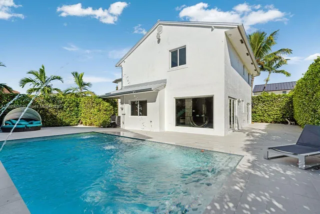 a white house with a white fence next to a yard