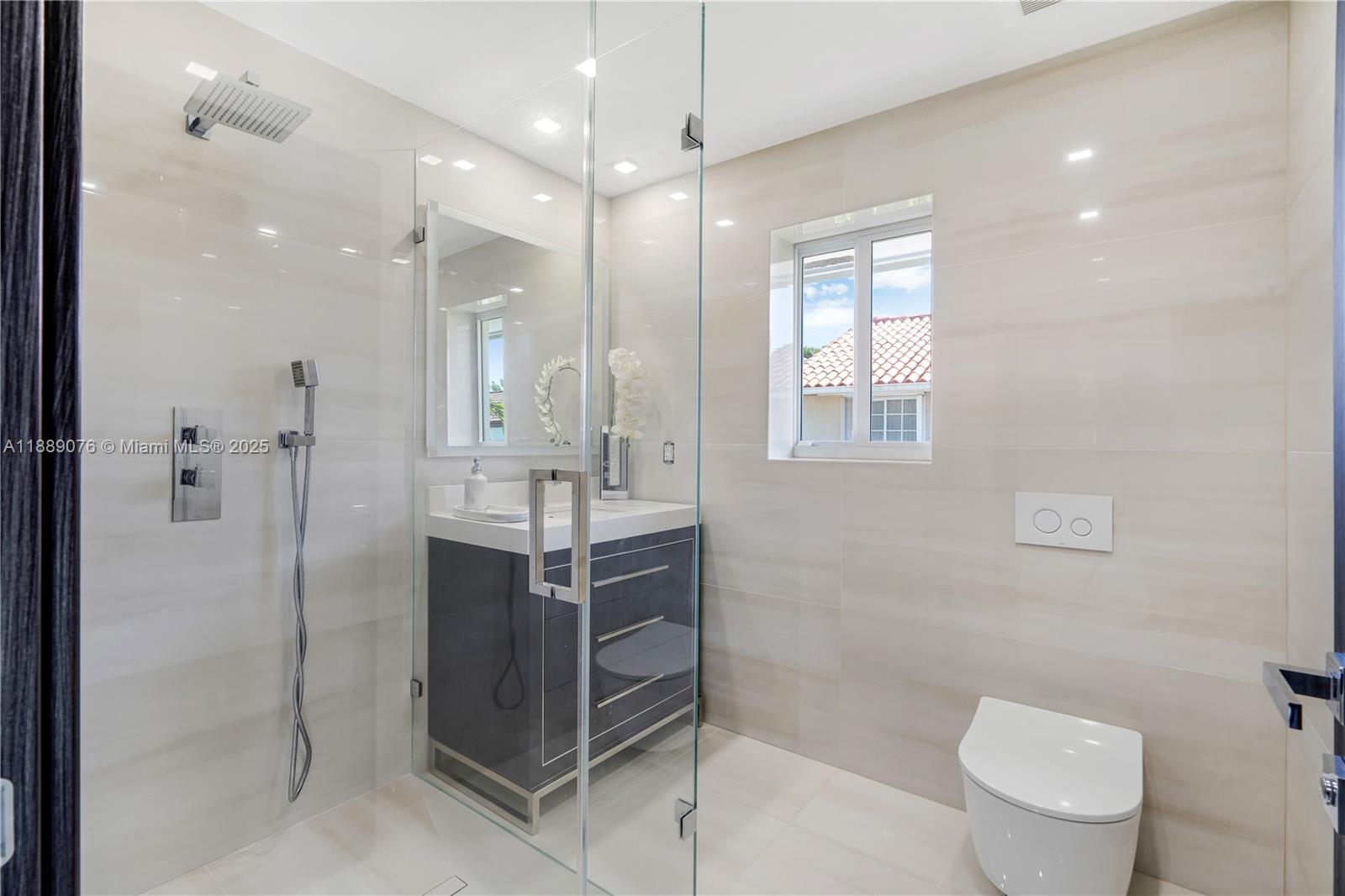 6763 Southwest 106th Place Miami, FL 33173 - Photo 21 of 38 a bathroom with a toilet a sink and mirror