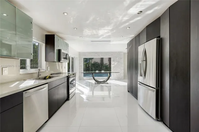 a kitchen with stainless steel appliances granite countertop a refrigerator and a sink
