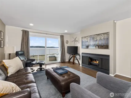 a kitchen with stainless steel appliances granite countertop wooden cabinets a sink dishwasher a stove and a refrigerator with wooden floor