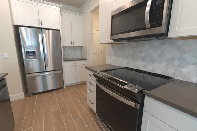 a view of a kitchen with furniture and wooden floor