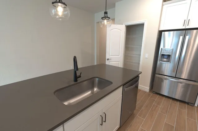 a view of kitchen with refrigerator sink and wooden floor